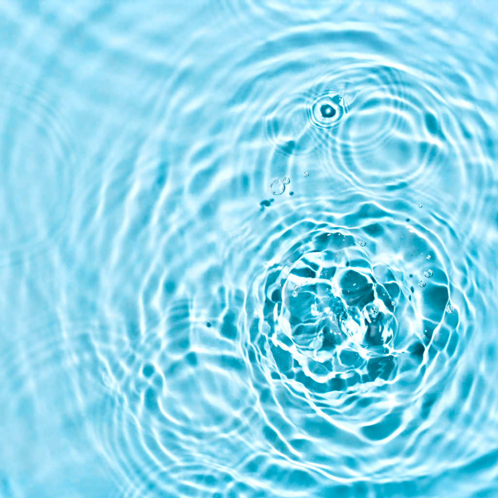 Ripples in turquoise water, symbolizing the interconnectedness of life and the fact that 71% of Earth is covered in water, just as our bodies are made mostly of water.