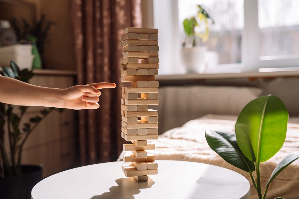 Ricky Jenga tower teetering, symbolizing the precarious balance of dabbling in magical practices.