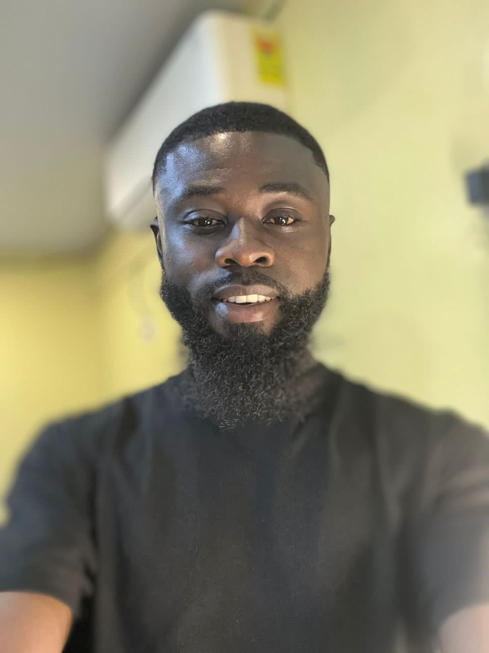 Ghanaian team member at 71 Connections smiling in a professional setting, representing the "Biggest Dog" in marketing leadership and social change.